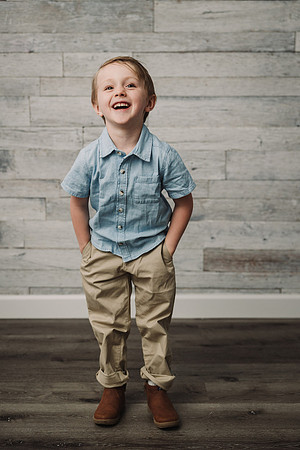 little boy laughing with his hands in his pocket
