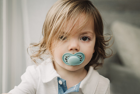 portrait of a little boy with a pacifier in his mouth
