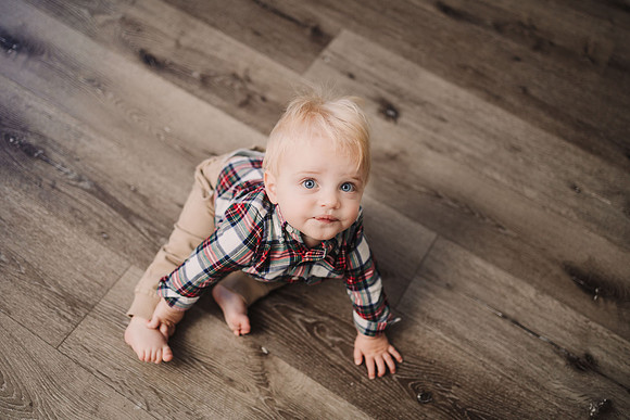 baby boy crawling across the floor of a phot studio