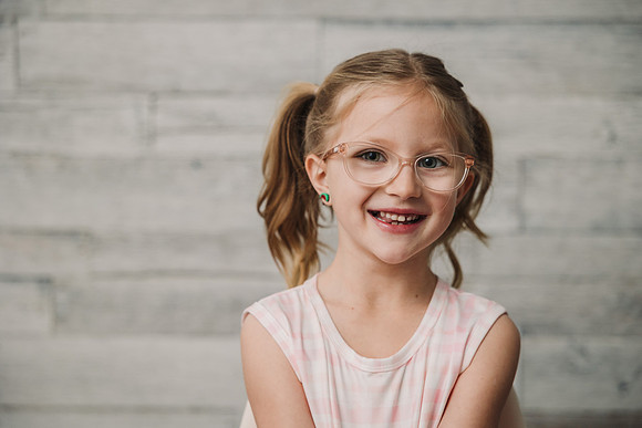 young girl with glasses that is smiling