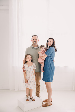 Portrait of a family of four in a white studio