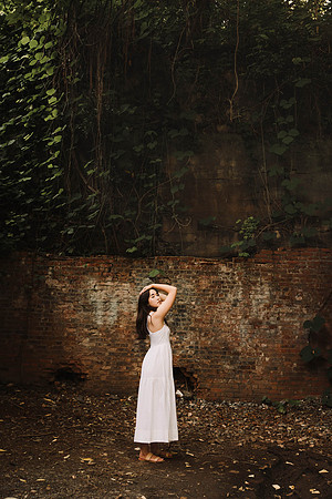 Teen girl with her arms above her head in a Mill ruin