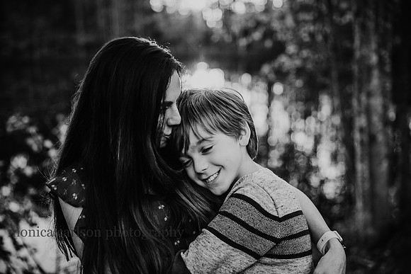 mom kisses her tween sons head
